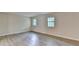 Wide view of a living room featuring two windows and light, modern flooring at 4384 Raven Valley Ct, Decatur, GA 30035