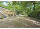 Yard view with fresh deck, painted brick, surrounded by mature shade trees in backyard at 5729 Jefferson Ave, Forest Park, GA 30297