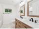 Bathroom with double vanity, framed mirrors, marbled floors, and a tub/shower combo with black fixtures at 5729 Jefferson Ave, Forest Park, GA 30297