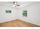 A bright bedroom has a ceiling fan, wood-look floors and two windows at 5729 Jefferson Ave, Forest Park, GA 30297