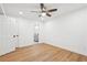 Bright bedroom features light wood flooring, a ceiling fan and a peek into a bathroom through an open door at 5729 Jefferson Ave, Forest Park, GA 30297