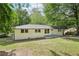 Charming painted brick home with a well-maintained lawn and mature trees at 5729 Jefferson Ave, Forest Park, GA 30297