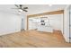 Open-concept living room with light wood flooring connected to modern kitchen with island at 5729 Jefferson Ave, Forest Park, GA 30297