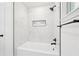 Shower featuring marble-style tile, rainfall showerhead, and a built-in niche for bath products at 5729 Jefferson Ave, Forest Park, GA 30297