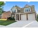 Charming two-story home showcasing a stone facade, a two-car garage, and manicured landscaping at 971 Reap Lane, Lawrenceville, GA 30043