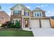 Charming two-story home showcasing a stone facade, a two-car garage, and manicured landscaping at 971 Reap Lane, Lawrenceville, GA 30043