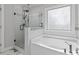 Modern bathroom showcasing a glass-enclosed shower, soaking tub, and mosaic tile accents at 704 Chipping Sparrow St, Canton, GA 30115