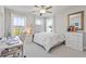 Bright bedroom with large windows, a tufted headboard, and a modern workspace at 704 Chipping Sparrow St, Canton, GA 30115