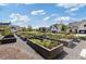 A community garden with raised garden plots and beautiful homes in the background at 704 Chipping Sparrow St, Canton, GA 30115
