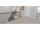 Well-lit upstairs hallway featuring a staircase and access to multiple rooms at 704 Chipping Sparrow St, Canton, GA 30115