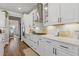 Bright kitchen featuring white cabinets, stainless steel appliances, quartz countertops, designer backsplash and hardwood floors at 704 Chipping Sparrow St, Canton, GA 30115