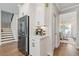 Kitchen area with stainless steel refrigerator, coffee bar, white cabinetry and hardwood floors at 704 Chipping Sparrow St, Canton, GA 30115