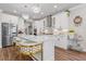 Bright kitchen with white cabinets, stainless steel appliances, quartz countertops, kitchen island and elegant lighting at 704 Chipping Sparrow St, Canton, GA 30115