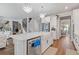 Open kitchen with white cabinetry, stainless steel appliances, kitchen island with porcelain sink and hardwood floors at 704 Chipping Sparrow St, Canton, GA 30115