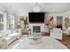 Bright living room featuring fireplace, large windows, stylish decor, plush carpet and hardwood floors at 704 Chipping Sparrow St, Canton, GA 30115