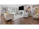 Sun-filled living room featuring a fireplace, large windows, stylish decor and hardwood floors at 704 Chipping Sparrow St, Canton, GA 30115