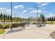 A concrete area with benches and picnic tables, with the tennis courts in the background at 704 Chipping Sparrow St, Canton, GA 30115