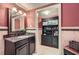 Well-lit bathroom with a vanity area, decorative walls, and a patterned tile floor at 125 Fortuna Ct, Roswell, GA 30075