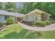 Charming single-story home with stone accents, a well-kept lawn, and a pathway leading to the entrance at 125 Fortuna Ct, Roswell, GA 30075