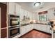 Well-lit kitchen featuring white cabinetry, stainless steel appliances, and hardwood floors at 125 Fortuna Ct, Roswell, GA 30075