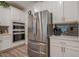 Kitchen area shows stainless steel refrigerator, double ovens, and matching white cabinets at 213 Hickory Bluffs Pkwy, Canton, GA 30114