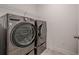 This laundry room features front loading washer and dryer with wire shelf above at 213 Hickory Bluffs Pkwy, Canton, GA 30114