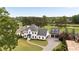 Aerial view of an elegant home on a golf course with a long driveway to a three-car garage at 2211 Lattimore Farm Nw Dr, Kennesaw, GA 30152