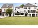 Spacious backyard showcasing a well-maintained lawn, a two-story house, and a stone stairway to the upper level deck at 2211 Lattimore Farm Nw Dr, Kennesaw, GA 30152