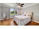 Comfortable bedroom with hardwood floors, two windows, and a ceiling fan at 2211 Lattimore Farm Nw Dr, Kennesaw, GA 30152