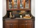 Butler's pantry with dark wood cabinetry, granite countertops, and decorative glass display cabinets at 2211 Lattimore Farm Nw Dr, Kennesaw, GA 30152