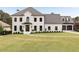 Stunning white painted brick home featuring manicured lawn and three car garage at 2211 Lattimore Farm Nw Dr, Kennesaw, GA 30152