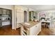 Open kitchen with granite island, custom cabinetry, stainless appliances, and connected dining and living areas at 2211 Lattimore Farm Nw Dr, Kennesaw, GA 30152