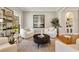 Bright living room with white armchairs, decorative tree, and hardwood floors at 2211 Lattimore Farm Nw Dr, Kennesaw, GA 30152