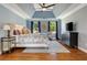 A spacious bedroom with a light blue ceiling, hardwood floors, and large windows at 2211 Lattimore Farm Nw Dr, Kennesaw, GA 30152