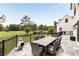 An outdoor stone patio with a dining table and seating that overlooks a golf course at 2211 Lattimore Farm Nw Dr, Kennesaw, GA 30152