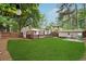 Large backyard with a lush lawn, patio area, and mature trees providing shade at 2586 Valley Stream Dr, Atlanta, GA 30360