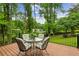 Relaxing back deck with an outdoor dining set overlooking the lush green backyard at 261 Demetra Se Dr, Mableton, GA 30126