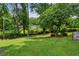 Picturesque backyard featuring a spacious lawn surrounded by mature trees and greenery at 261 Demetra Se Dr, Mableton, GA 30126