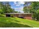 Brick home with deck overlooking a large grassy yard with mature trees, perfect for outdoor enjoyment at 261 Demetra Se Dr, Mableton, GA 30126