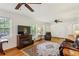 Spacious living room featuring hardwood floors, ceiling fans, and a cozy fireplace at 261 Demetra Se Dr, Mableton, GA 30126