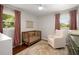 Cozy Bedroom with a wooden crib, cream colored armchair, and decorative rug at 283 Norton Se Cir, Smyrna, GA 30082
