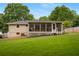 Home's back exterior featuring a screened-in porch, spacious yard, and traditional architecture at 283 Norton Se Cir, Smyrna, GA 30082