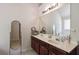 Bathroom featuring double sink vanity with wood cabinets, large mirror, and elegant lighting at 6252 Selborn Sw Dr, Atlanta, GA 30331