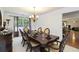 Formal dining room featuring a dark wood table, elegant chandelier, and large window for Gathering gatherings at 6252 Selborn Sw Dr, Atlanta, GA 30331