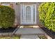 Close-up of a white front door, adorned with glass detailing and flanked by meticulously trimmed bushes at 6252 Selborn Sw Dr, Atlanta, GA 30331