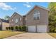 Two-story brick home with double garage, manicured bushes and large arched windows for lots of light at 6252 Selborn Sw Dr, Atlanta, GA 30331