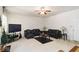 View of a modern living room with a ceiling fan, black leather furniture, and a black entertainment center with a television at 6252 Selborn Sw Dr, Atlanta, GA 30331