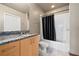 Bathroom with a granite countertop vanity, tile floors, and a shower tub with black curtain at 943 Peachtree Ne St # 1010, Atlanta, GA 30309