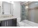 Modern bathroom with stylish gray tile, glass shower doors, and a granite vanity at 120 Burford Holw, Alpharetta, GA 30022