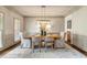 Formal dining room featuring stylish lighting, neutral decor, and elegant table setting for sophisticated dining at 120 Burford Holw, Alpharetta, GA 30022